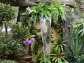 Garten-Wasserfall mit Tropenblumen und lila Orchideen